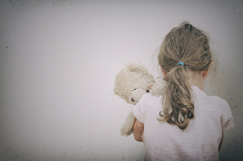 child hugging teddy bear