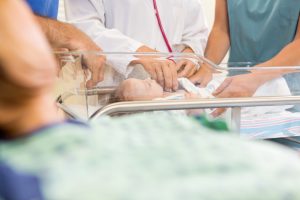 obgyn checking pulse of a baby after birth