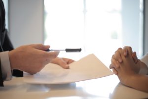 Lawyer and Insurance Adjusters singing paperwork after accident