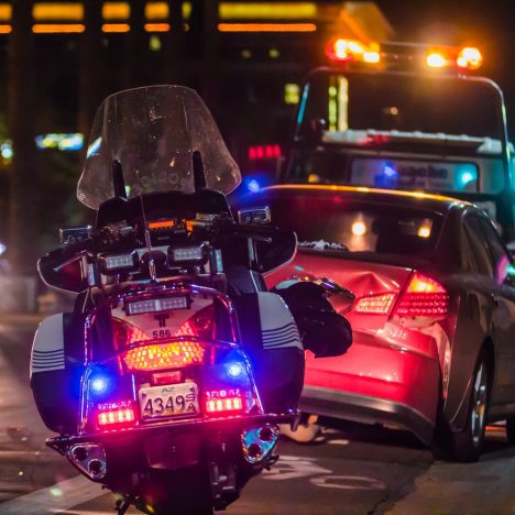 Police motorcycle behind car crash